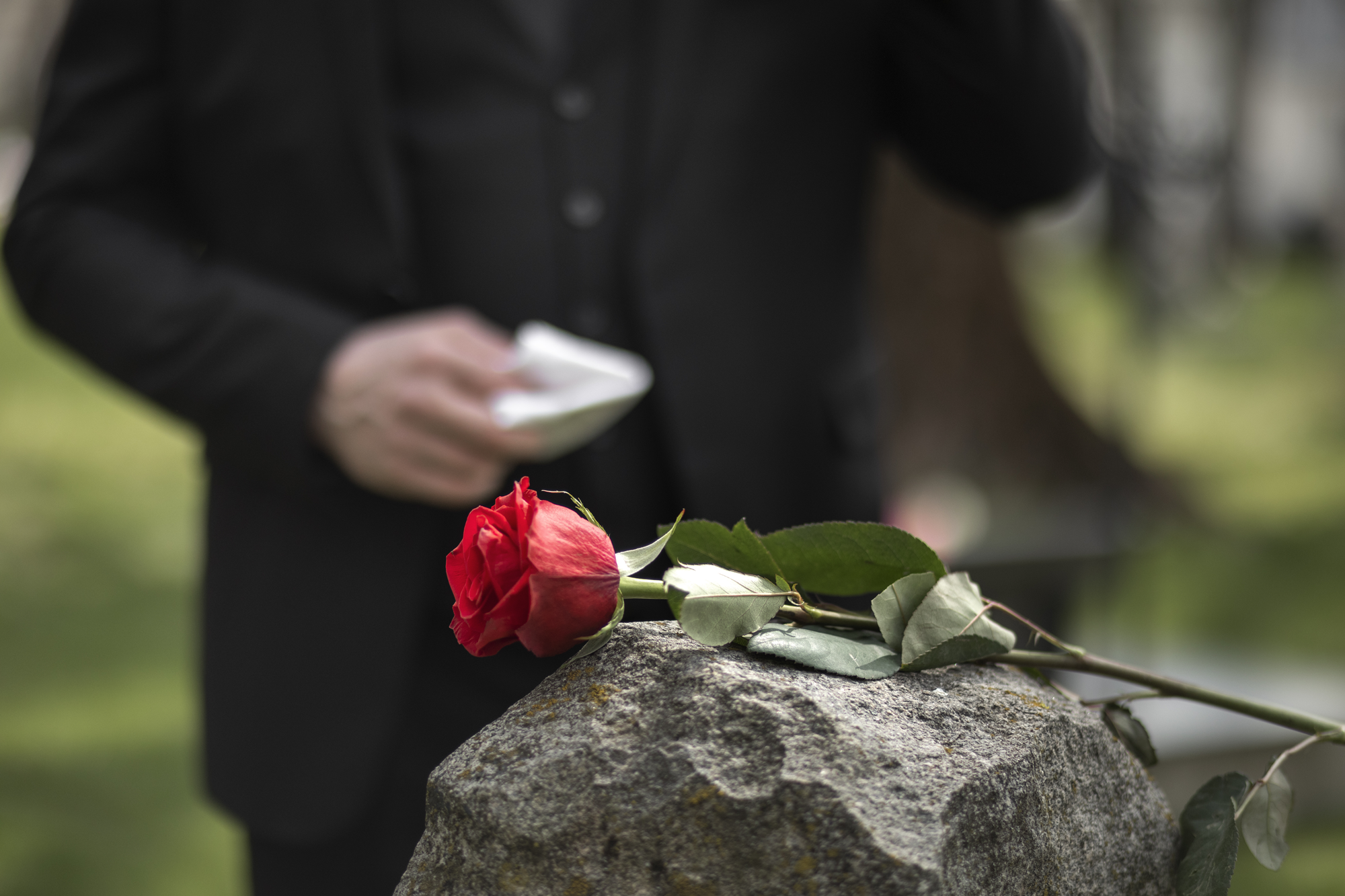homme-rendant-hommage-a-une-pierre-tombale-au-cimetiere